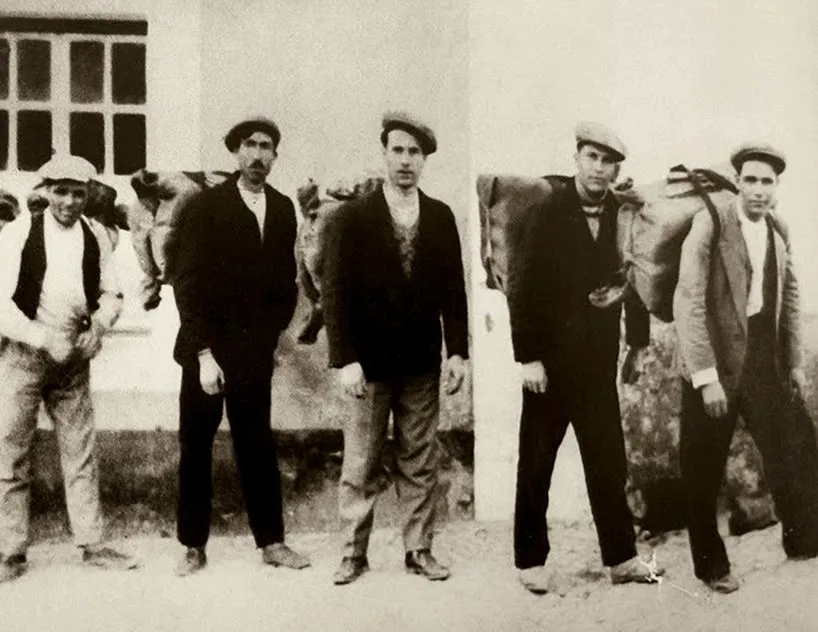 Com sacos às costas, carregados de café, os contrabandistas atravessam a fronteira de Espanha. Joaquim dos Santos Nabeiro é o terceiro na foto.